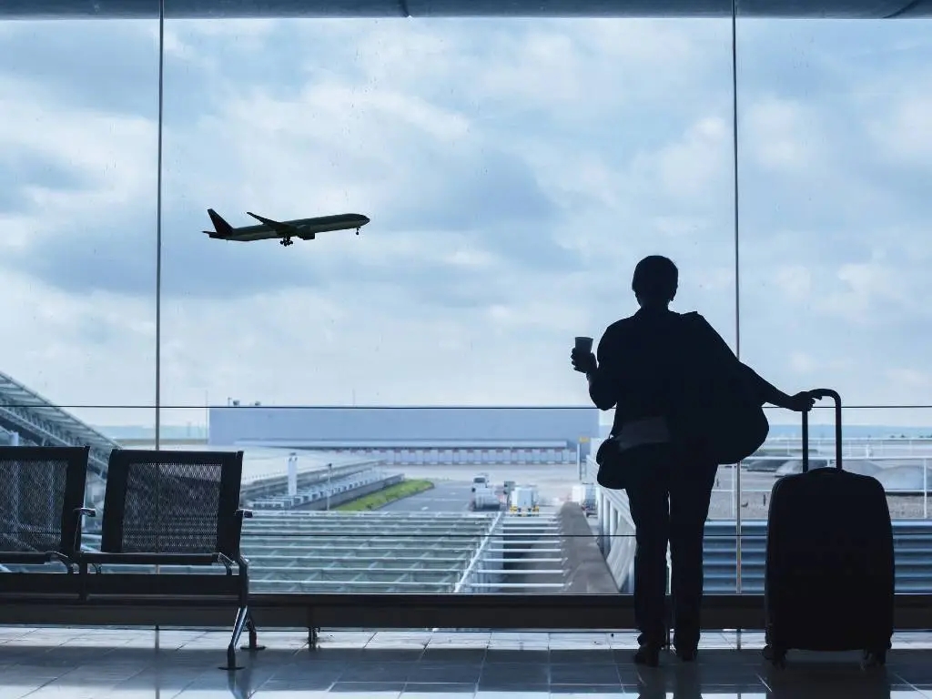 woman watching planes take off at airport.