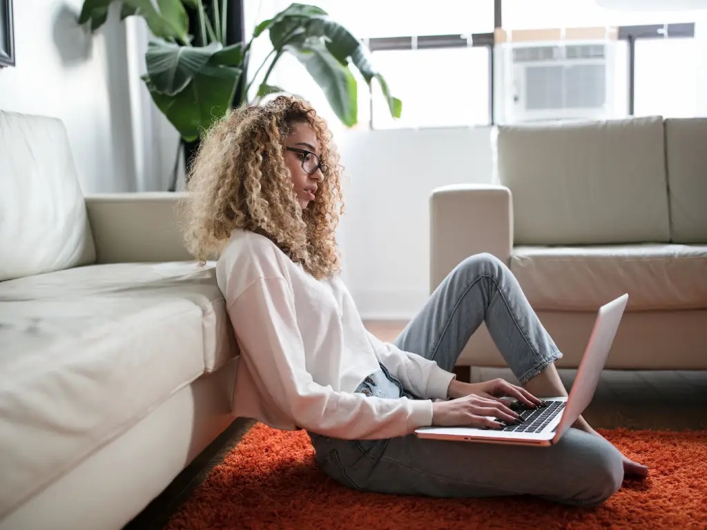 woman sitting on floor using a laptop
