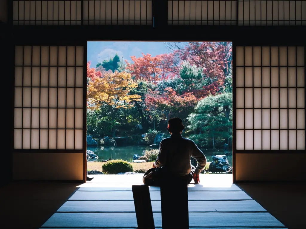 person sitting in the doorway of a traditional home in Japan